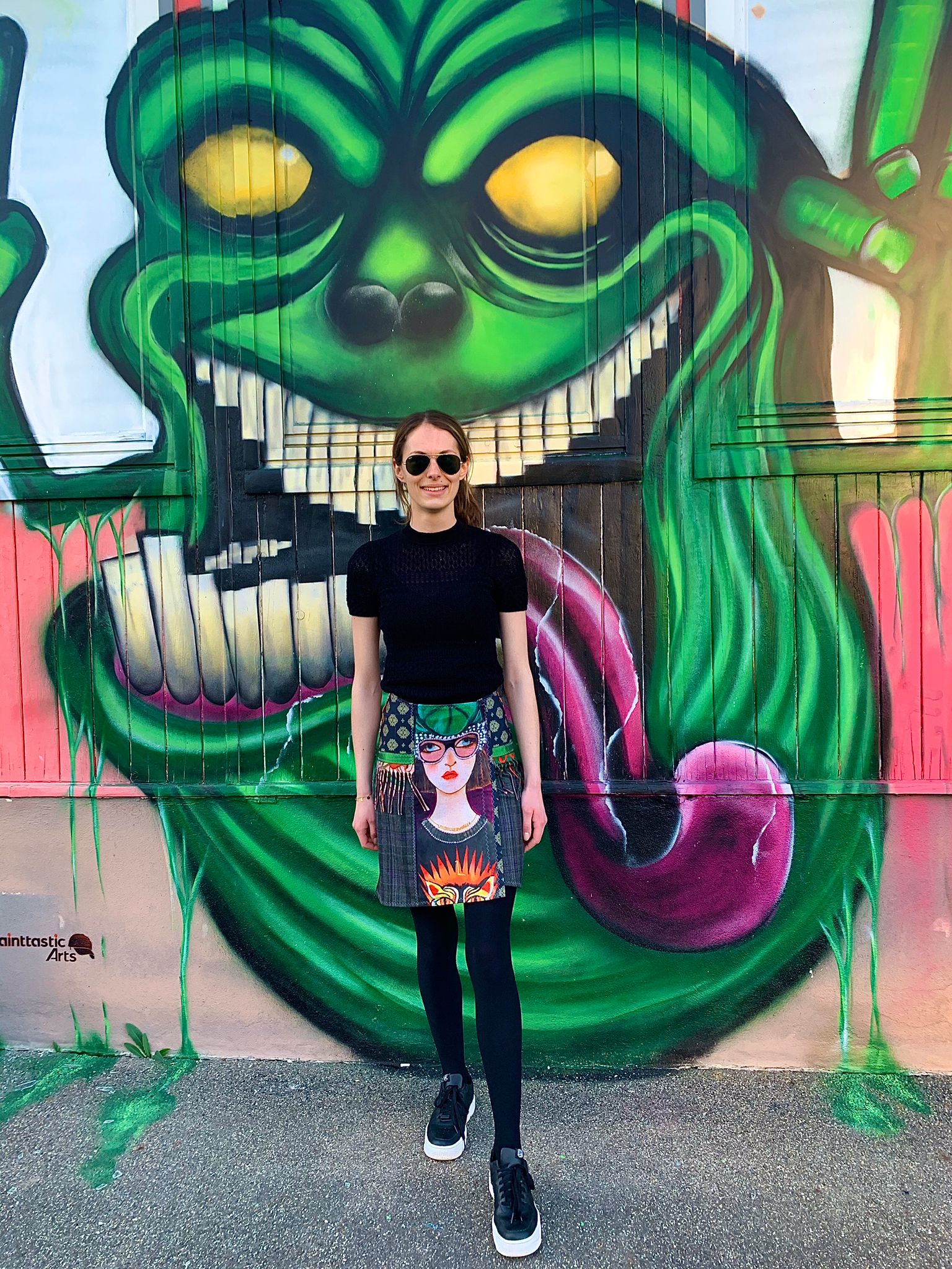 Frau mit Designerrock vor einer Grafitiwand