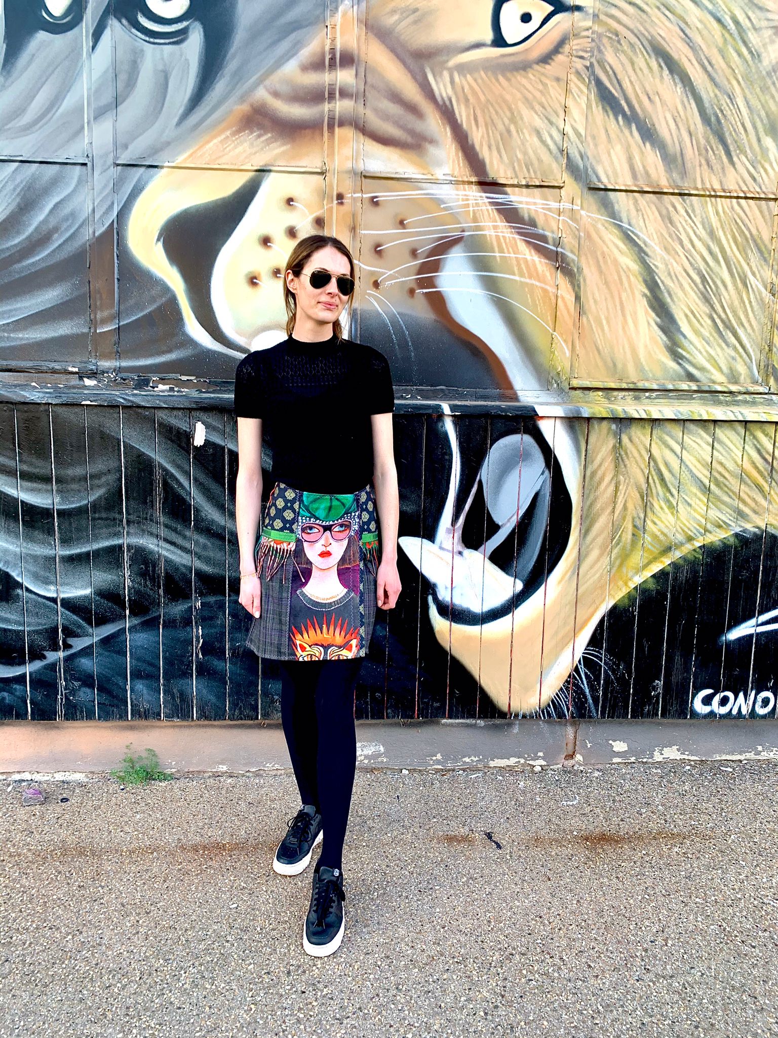 Frau mit Designerrock vor einer Grafitiwand